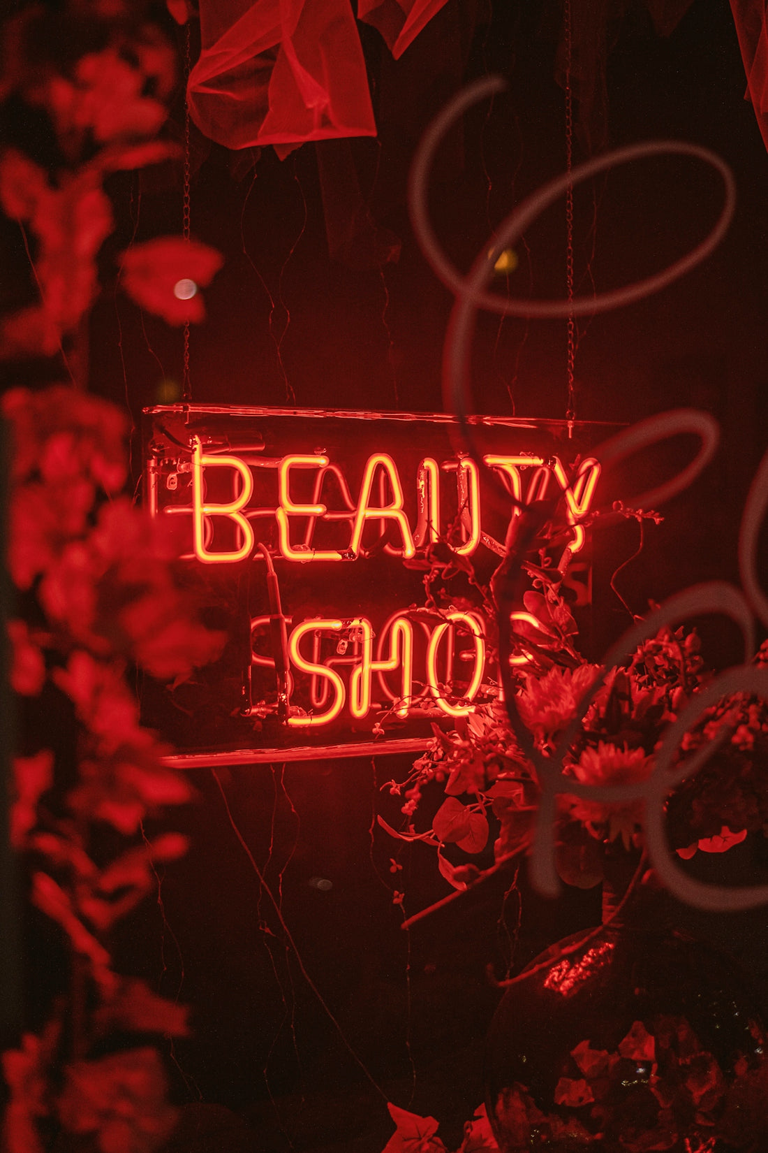 a red neon sign that says beauty shop