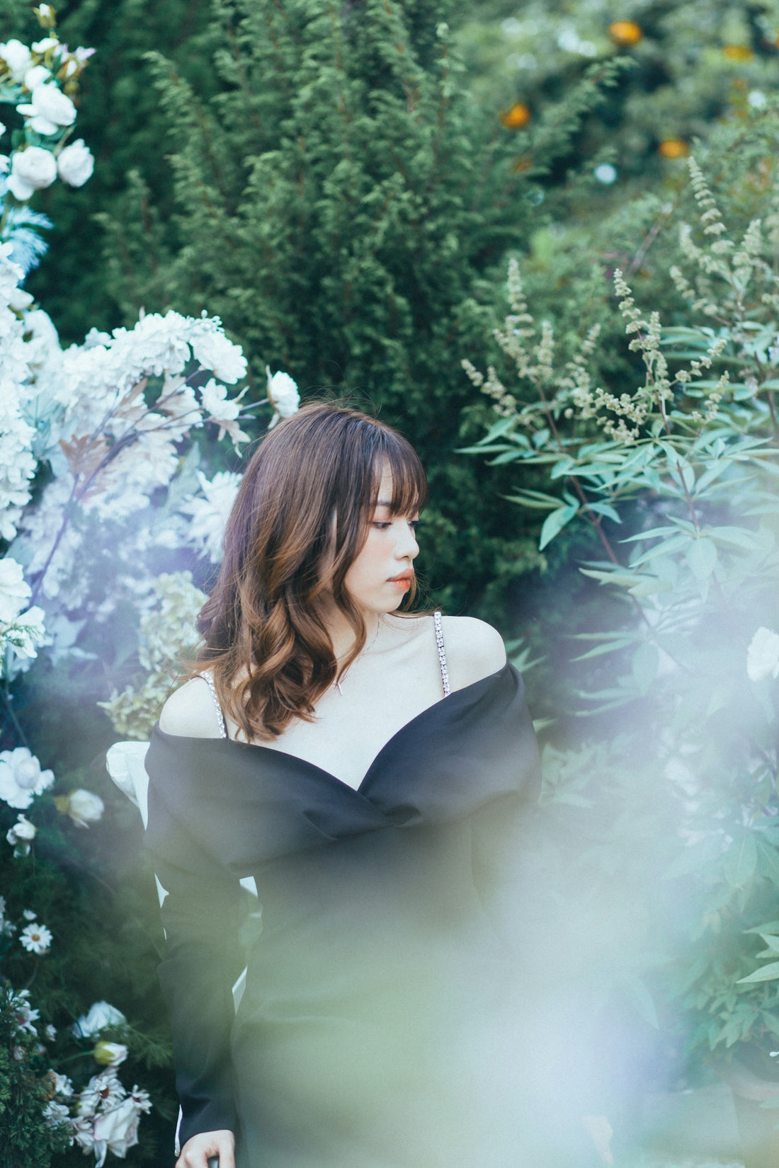 a person posing in front of a bush